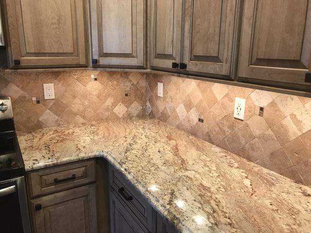 Closer view of the granite counter tops as well as the tile wall.