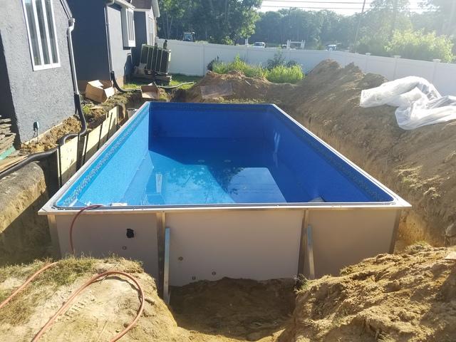 The liner is being stretched out by slowly filling the pool with water. This makes the liner go on smoothly and avoid rips and tears!