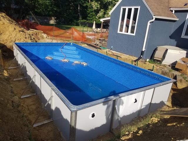 The liner is being stretched out by slowly filling the pool with water. This makes the liner go on smoothly and avoid rips and tears!