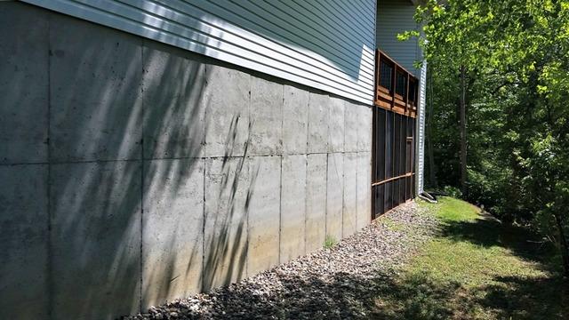 Before repairing his foundation, he had a large crack in the wall and a large crack on the garage floor.