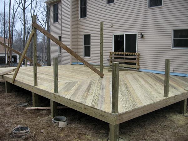 The team installs base beams for support and lays down a floor, while starting to building the outer fence.