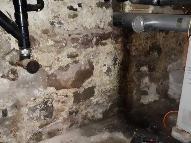 The crawl space was leaking, which, combined with the porous mortar used in the stone foundation, resulting in continuously high humidity levels and a damp, musty environment which affected the entire home.