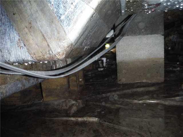 Standing water on the floor of this crawl space and water droplets on the wiring and HVAC venting in Georgetown, DE.