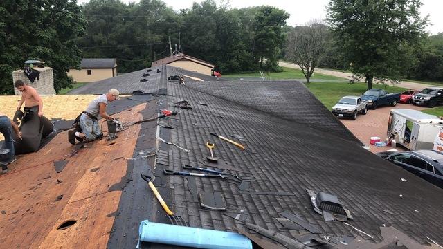 Our crew of roofers works to remove the existing roofing shingles to prepare for a roof replacement.