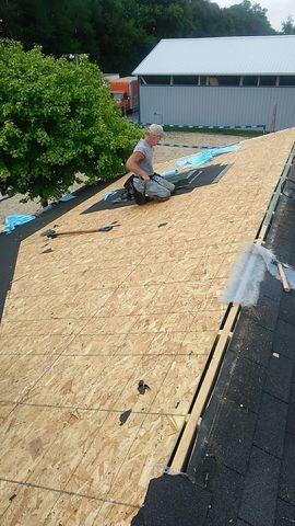 Roofing shingles are removed down to the decking in order to prepare for a roof replacement.