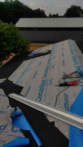Our crew of roofers installing a synthetic roof underlayment on the
roof decking.
