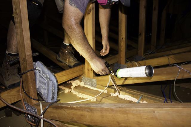 Diego is air sealing an attic.