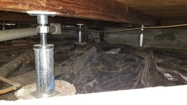 Homeowner replaced wooden posts in crawl space with steel Smart Jacks to stabilize and support floor.