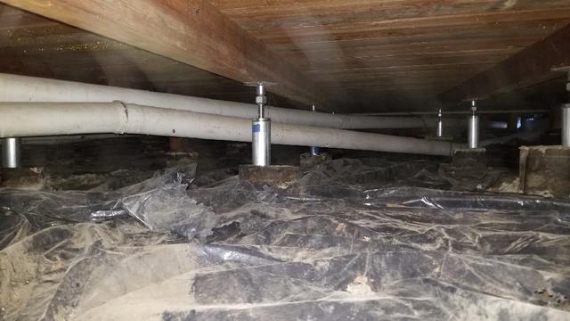 Homeowner replaced wooden posts in crawl space with steel Smart Jacks to stabilize and support floor.