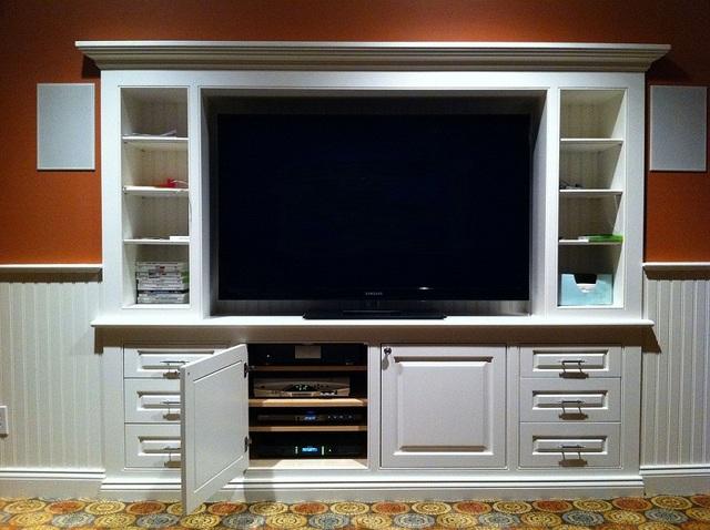 entertainment system flat screen in custom built in with hidden equipement showing