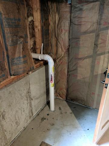 View of the system drawing the radon particles from underneath the slab and venting them out of the basement.