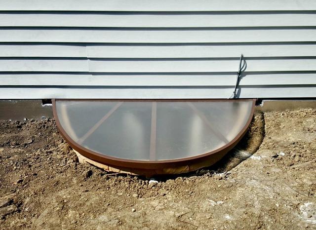 The polycarbonate safety cover has been installed to keep leaves and debris out while still allowing natural sunlight and fresh air to enter the basement. It is not intended for foot traffic, but it can hold up to 500 lbs and can prevent family members from accidentally falling into the window well.