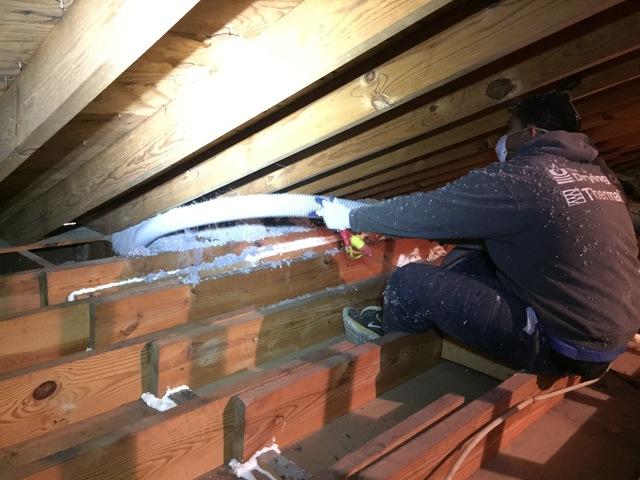 Blown-in insulation is sprayed into the attic using a tube that connects to one of our trucks, outside the home. Inside the truck, a team member is feeding in bags of cellulose insulation, while another team member inside the attic is blowing-in the new blanket of insulation.