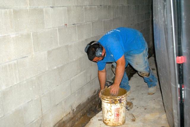 <p>The crew jackhammers away the concrete on the edges and then removes most of the crud before laying down the WaterGuard system.</p>