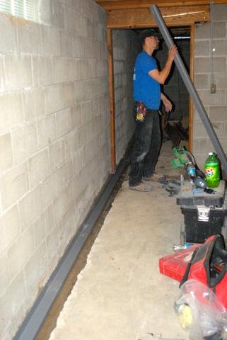 <p>The crew works hard to cut and prepare the WaterGuard to fit around the perimeter of the basement.</p>