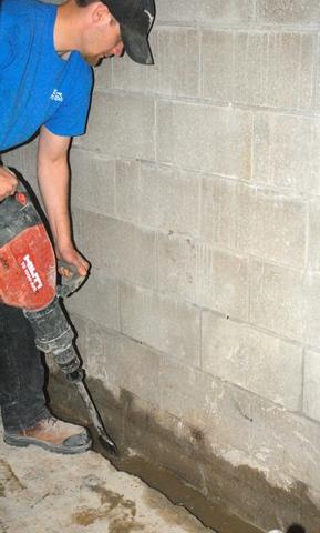 <p>Here's one of our crew members jackhamming away to even out the surface for the WaterGuard system to sit on.</p>