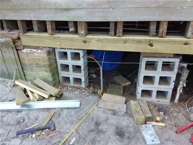 Before the subfloors could be supported, some of the house's original wooden beams needed to be replaced.