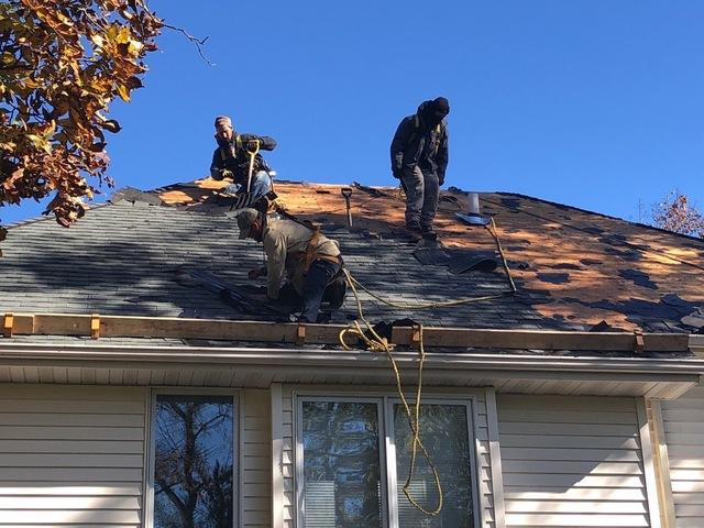 <p>A few of the guys are removing this roof slope together as a team.</p>