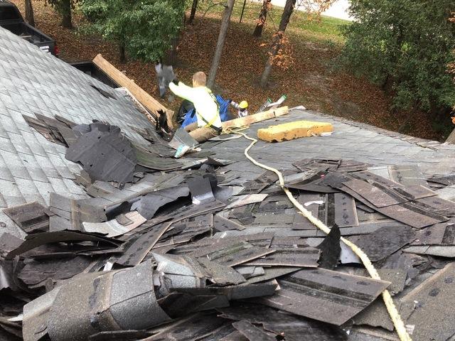 <p>We are moving the old roof shingles down the roof to have Tommy throw them in the dump trailer.</p>