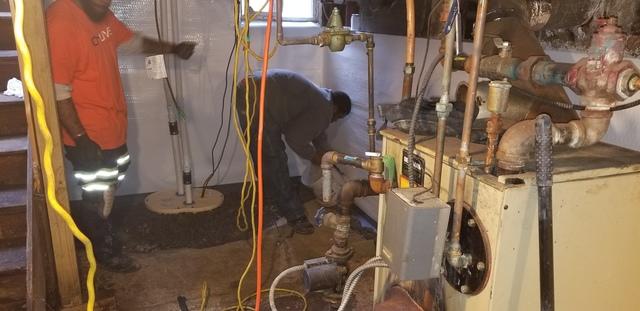 Travis and Larry installing the TripleSafe sump pump system with WaterGuard along the perimeter.