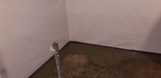 A close view of the waterproofed basement via the WaterGuard on the floors around the perimeter with cement laid over it, and CleanSpace around the walls