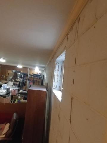 The cracks along the front basement wall are visible and past water damage is present.