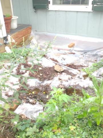 Front Exterior of home with plastic sheets to help prevent moisture and water from entering into basement