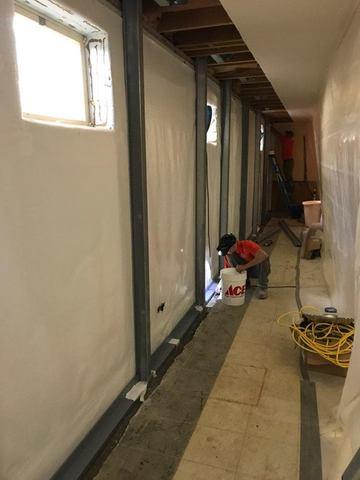 With the Waterguard installed and the window openings cut and sealed around the perimeter of the ClenaSpace Wall, the crew is working to fill the floor with concrete and finish the area.   In the far corner, the crew is also getting the Super Sump ready for installation.