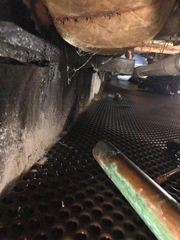 Drainage matting is placed in the crawl space before the clean space is installed. During this time the crew discovered a broken water line. Repairs were made before moving forward with the rest of the installation.