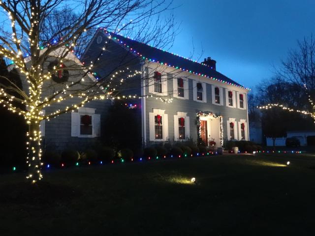 Multicolored ground stakes and roof lights make this Christmas display in Wall, NJ fun and festive