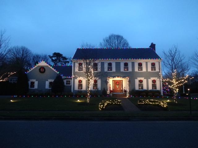 Multicolored ground stakes and roof lights make this Christmas display in Wall, NJ fun and festive