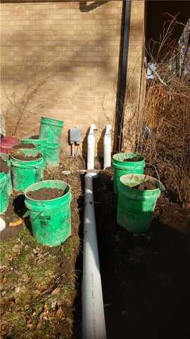 The Triple Safe sump pump discharge line is installed to ensure the water is directed away from Amy's home.