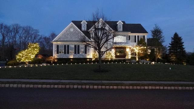 This homeowner welcomes guests with lit garland spiraled around their entrance pillars!