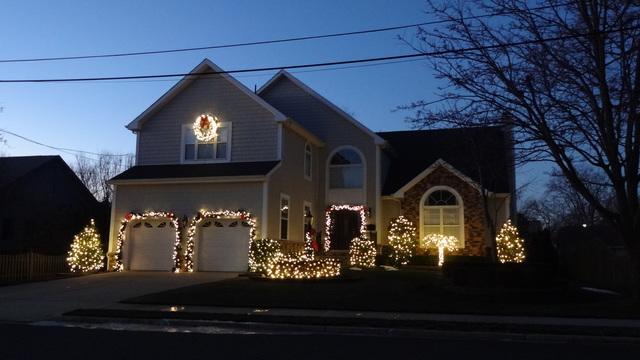 This homeowner highlights his landscaping with Christmas lights on all of the trees and shrubs in front of his home! Lit garland up the lamp post adds a classic touch to this display.