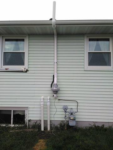 View of outside home after radon mitigation system installation.