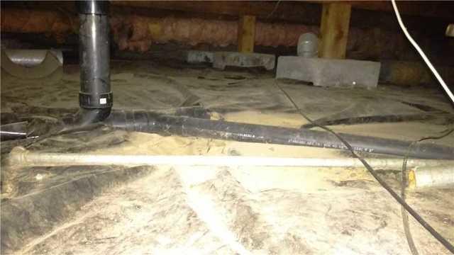 Exposed piping and dirt crawlspace