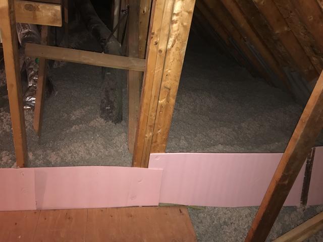 This pink board is separating the footprint of the inside of the home from the garage area. You do not need to insulate over a garage in most homes and it can trap airborne VOC's.