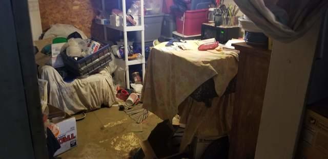 A room filled with stuff and 6 inches of mud and water covering all the corner items