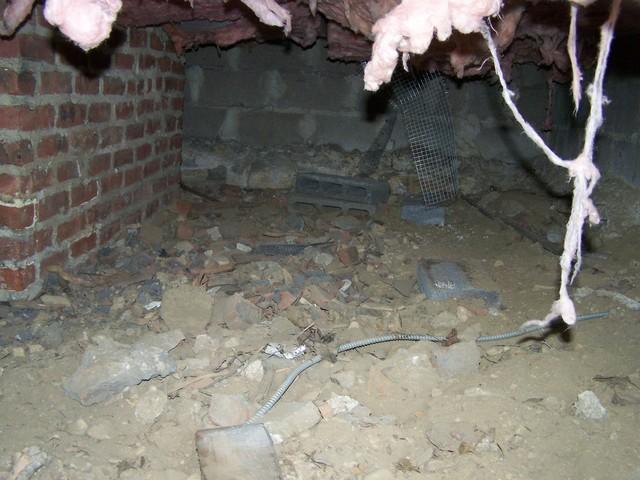 This debris-filled crawl space had a dirt floor, which allows moisture to seep into the house. To fix this problem, we installed our TerraBlock™ Crawl Space Floor Insulation. This product includes a white vapor barrier that will keep moisture from making its way up through dirt, stone, or concrete crawl space floors.