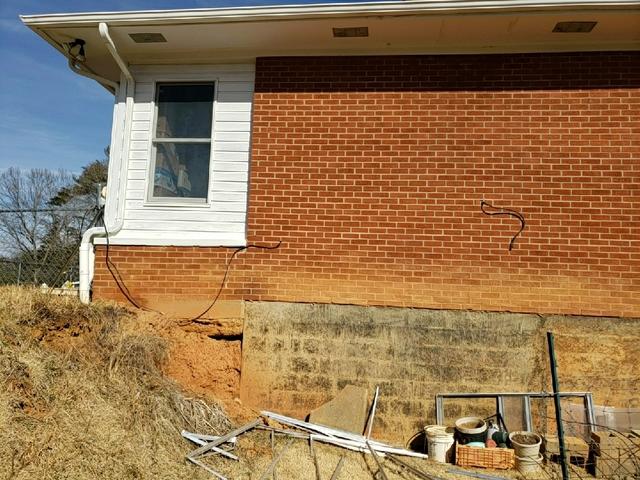 Visible erosion of the soil beneath the foundation of the home