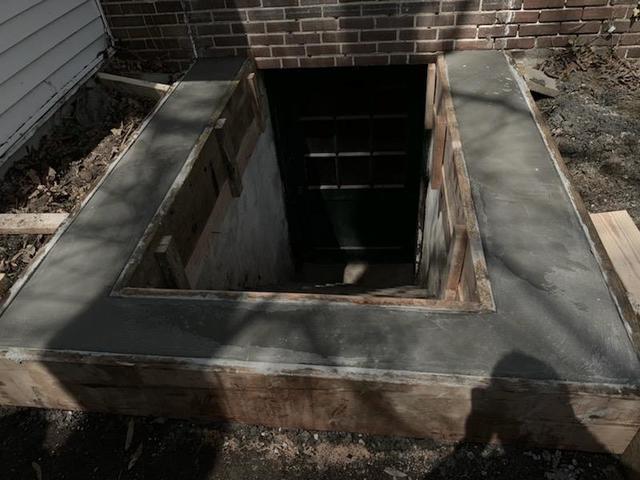 Finished concrete foundation repairs before cellar door replacement.