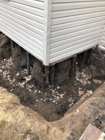 Soil is removed from the area where the helical piers will be installed. Helical pier sections are mechanically  advanced into the soil. Once proper depths and capacities are achieved, heavy duty steel foundation brackets are positioned below and against the foundation footing.