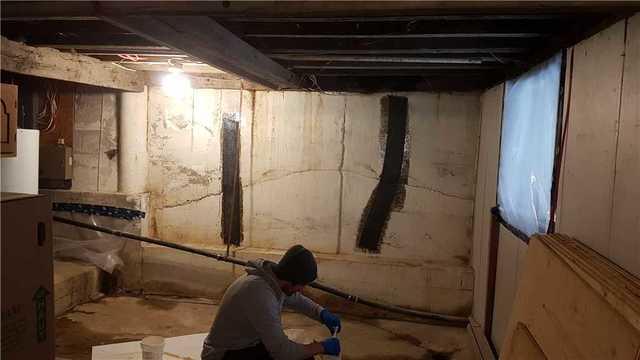 Installation des bandes en fibres de carbone pour stabiliser le mur