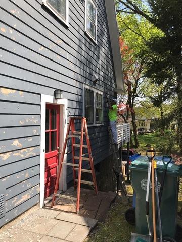 Sanding off peeling paint before adding new paint.