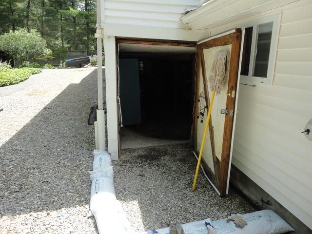 A door leading outside from the Columbia, CT basement allowed water to enter the basement. To prevent this from happening and get the basement much more dry, we installed a trench drain at the entrance of the basement. Its open grate collects water into the WaterGuard sub-floor perimeter drainage system, and it is directed out of the basement. The basement is now dry for the homeowners to enjoy.