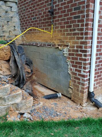 Because of foundation settlement, The bricks on the side of the house were cracking. Under the cracking bricks was cracking along the cinderblock wall of the house.