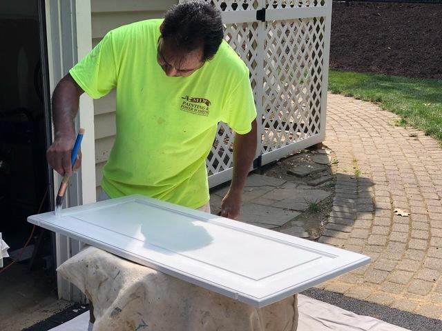 Cabinet door is laid out to be painted so every inch is covered in fresh paint.