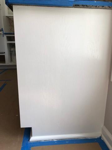 Adding another coat of paint to this cabinet wall for a solid white color.