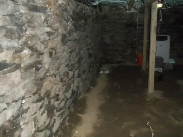 The crawl space of this Yantic, CT home was very wet. Water seeped in through the dirt floor and through small cracks in the fieldstone foundation walls. This greatly increased the humidity of the area, encouraging mold growth, mildew, and rot. It was not a usable area for the homeowners and was only a liability beneath the home. 