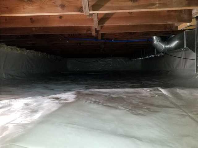 This crawl space had an uneven floor, which can be a safety issue. The bright white vapor barrier improves visibility to reduce injury risk.